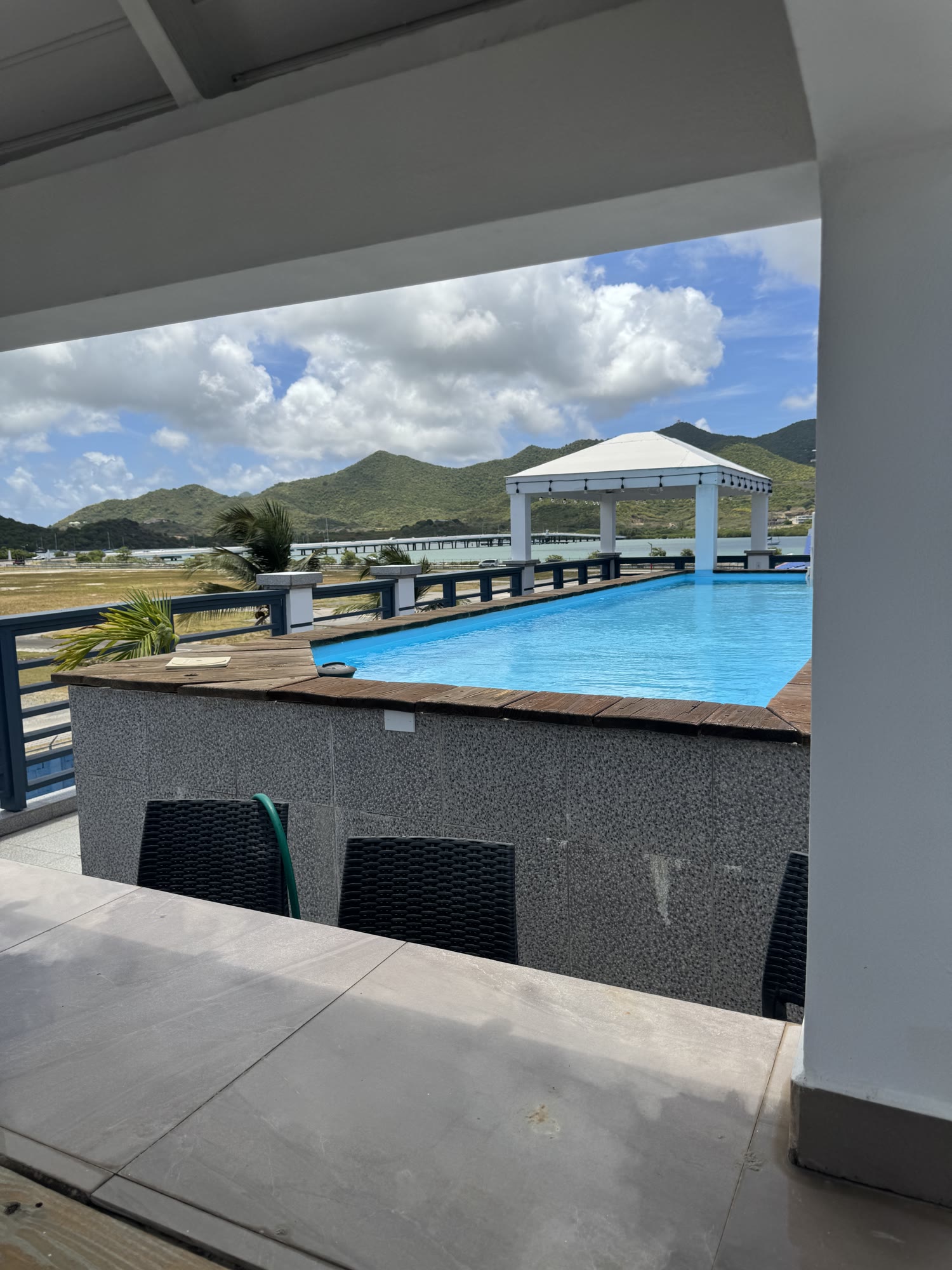 Pool loungers looking across the bay — the island neighbour rate